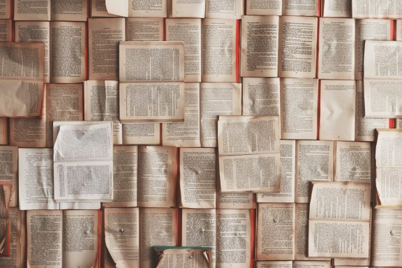 A collage of open books with visible text and pages layered over each other.